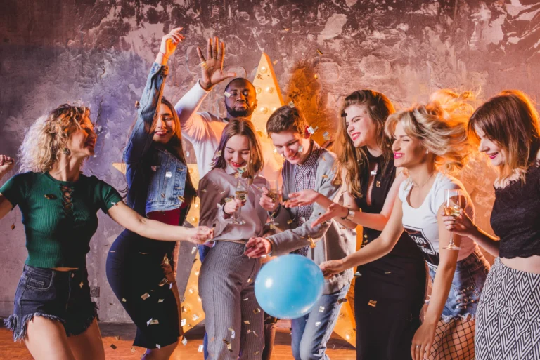 Friends enjoying a party with confetti and balloons