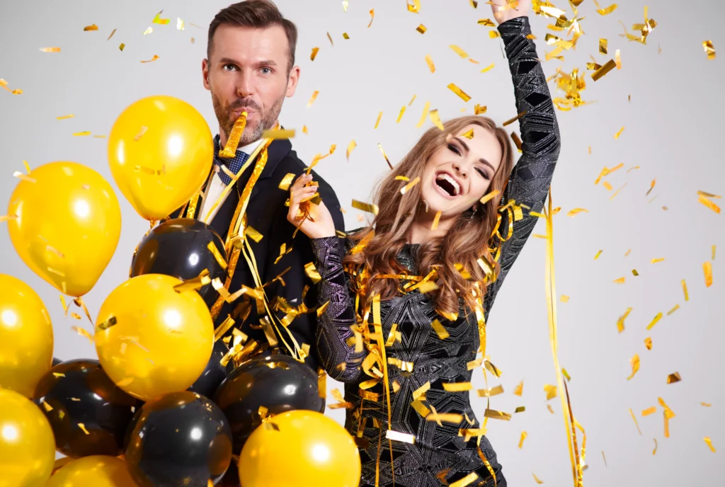 Couple dancing under falling confetti and streamers