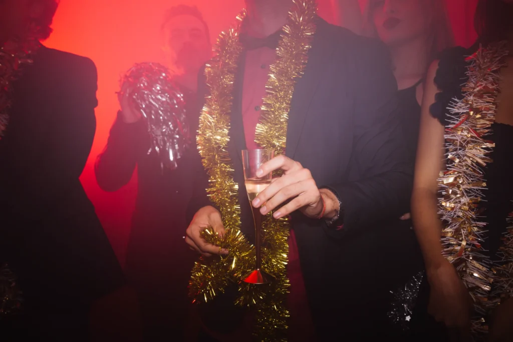 Man holding a glass at a New Year’s club party